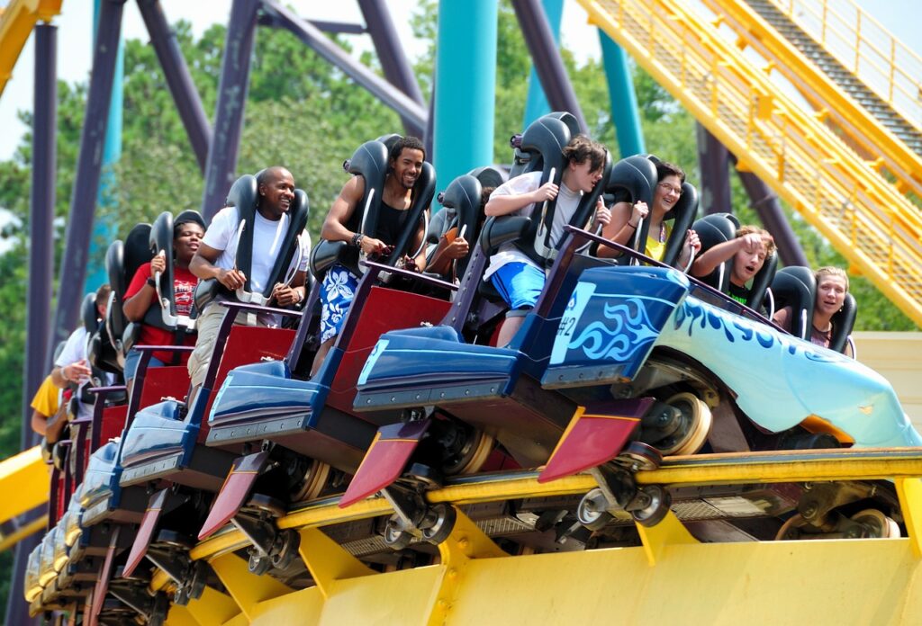 roller-coaster-1701085_1280 - Colorado Frontiers People riding a blue roller coaster car on a yellow track at an amusement park on a sunny day